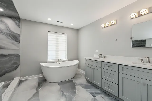 a spacious bathroom with a bathtub sink and mirror