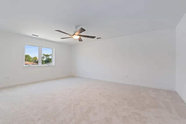 an empty room with a ceiling fan and window