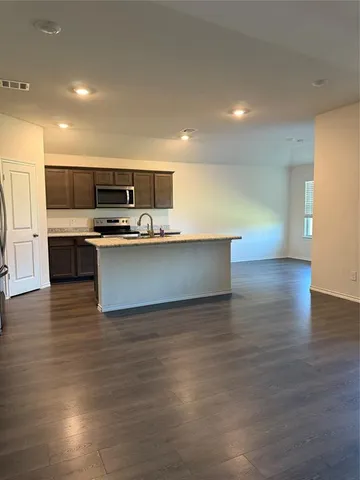 a view of kitchen with stainless steel appliances a sink and a stove top oven