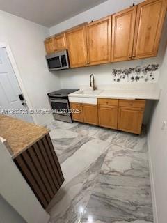110 Northeast 68th Street, Unit B Miami, FL 33138 - Photo 7 of 7 a kitchen with a stove and a sink