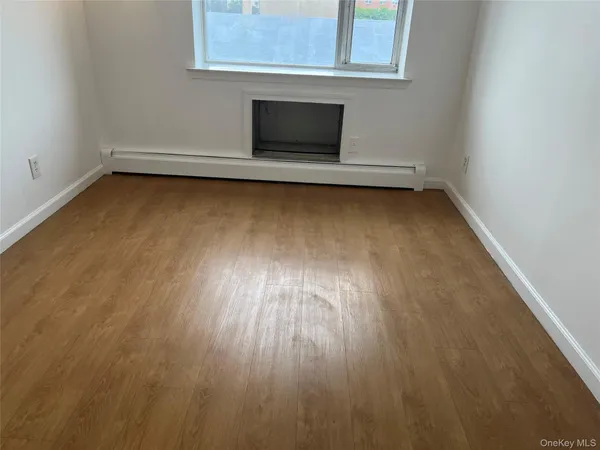 a view of a room with wooden floor and a window