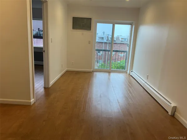 an empty room with wooden floor and a window