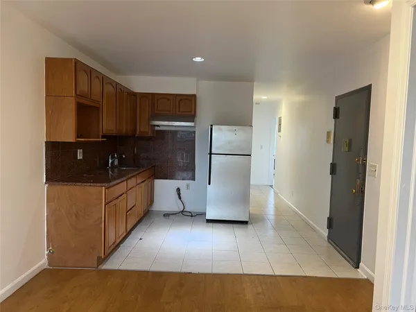 a kitchen with a refrigerator a stove top oven a sink and cabinets