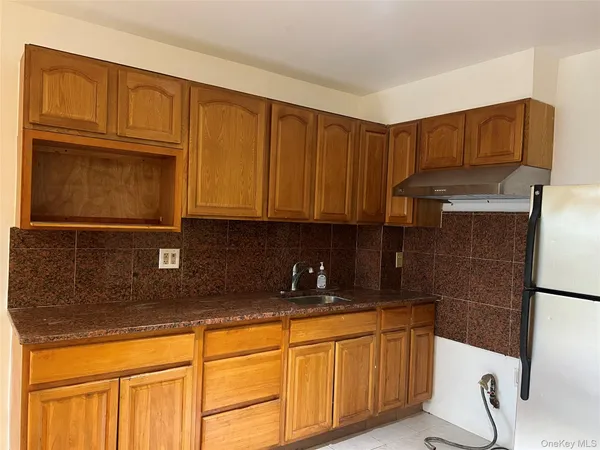 a kitchen with granite countertop cabinets stainless steel appliances a sink and wooden floor