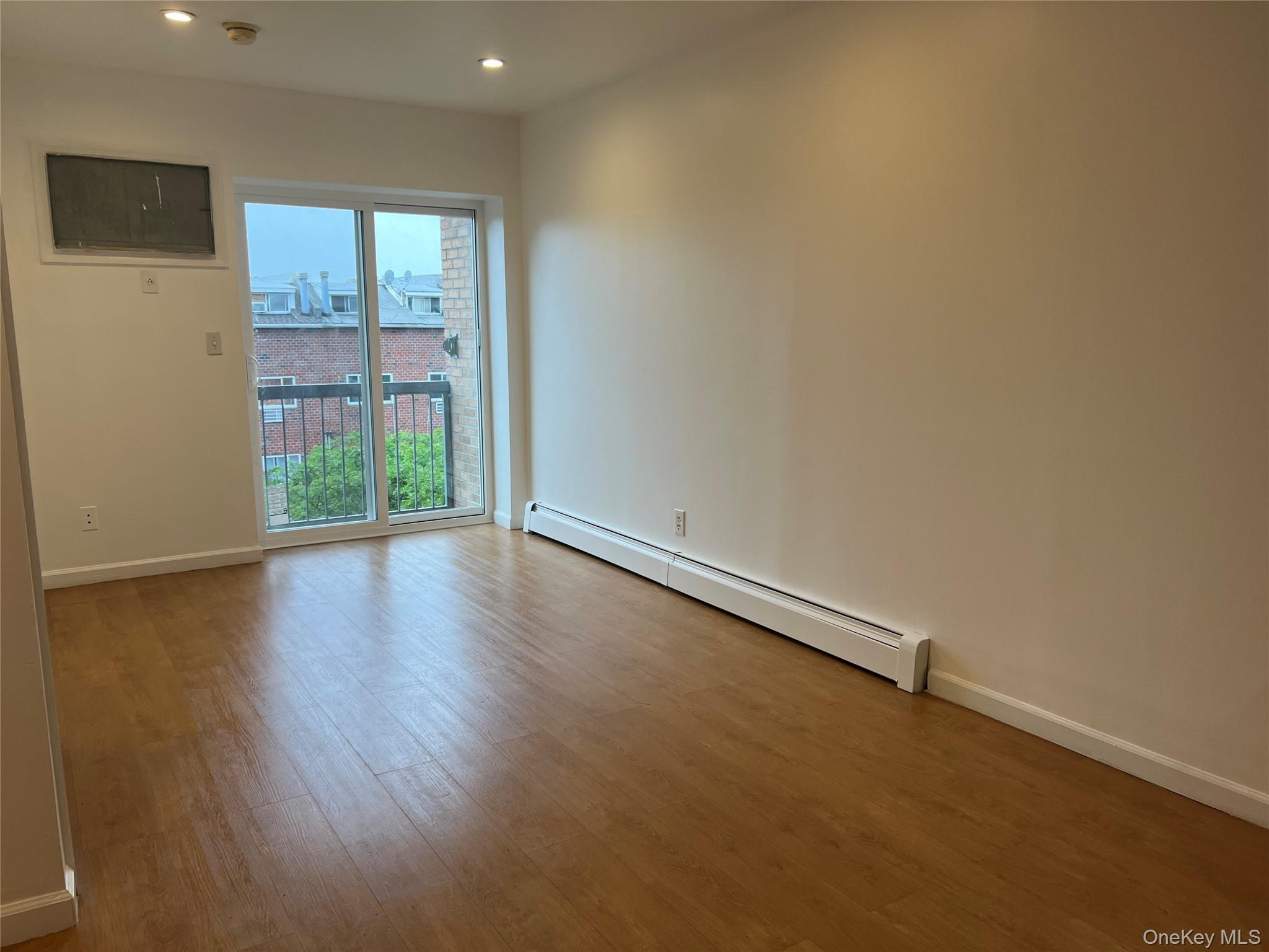 55-05 98th Street Queens, NY 11368 - Photo 9 of 12 Empty room with a baseboard radiator, wood finished floors, recessed lighting, a smoke detector, and baseboards