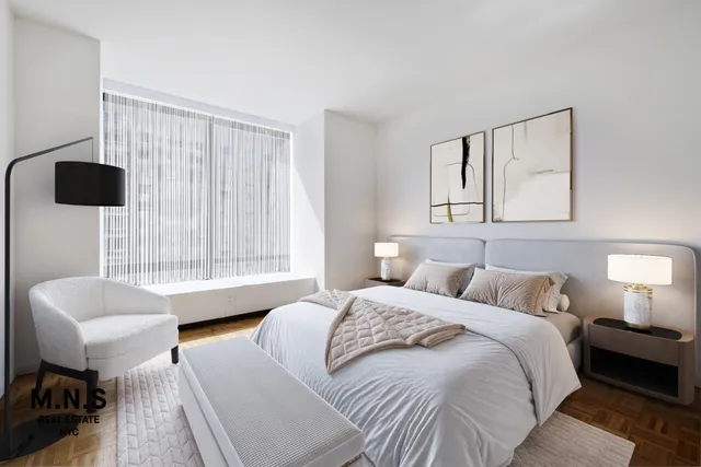 a bedroom with furniture and a large window