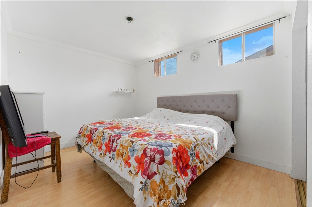 121 East 68th Way Long Beach, CA 90805 - Photo 14 of 17 a bedroom with a bed and wooden floor