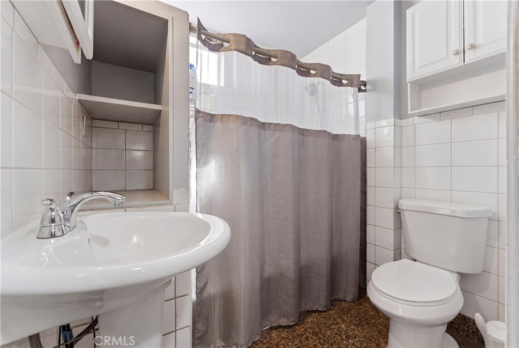 121 East 68th Way Long Beach, CA 90805 - Photo 15 of 17 a bathroom with a sink toilet and shower