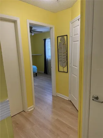 a view of a hallway with wooden floor and closet