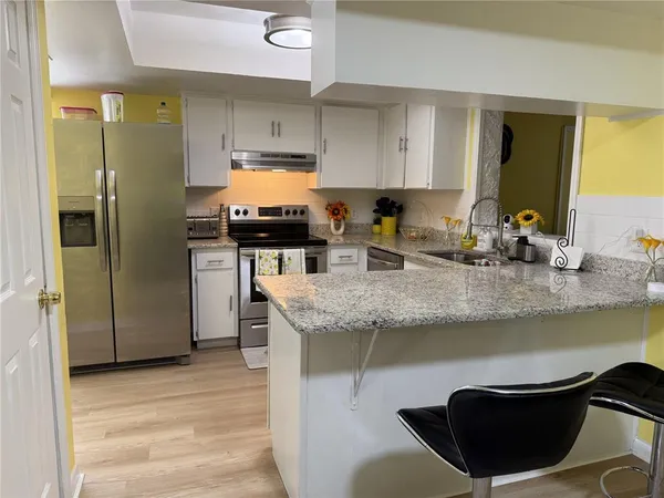 a kitchen with stainless steel appliances granite countertop a sink stove and refrigerator