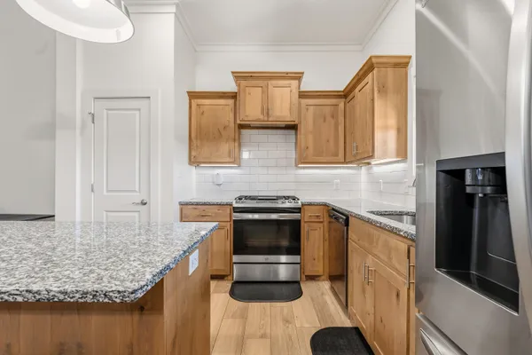 a kitchen with stainless steel appliances granite countertop a sink stove and cabinets