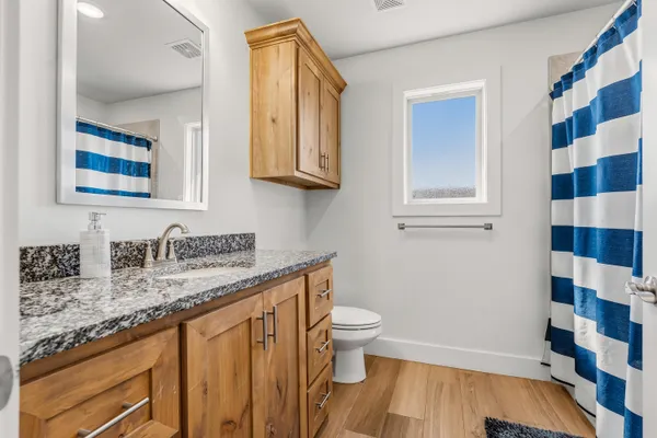 a bathroom with a granite countertop sink and a mirror