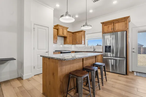 a kitchen with refrigerator cabinets and wooden floor