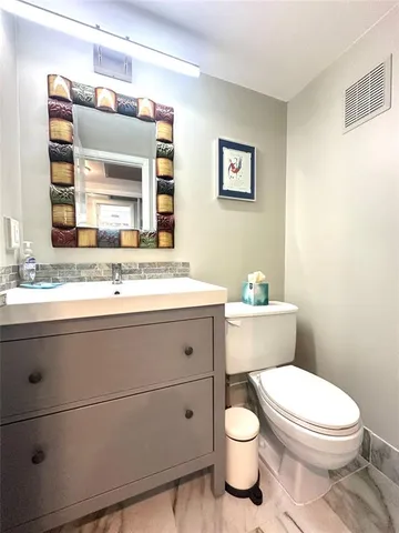 a bathroom with a toilet a sink and mirror