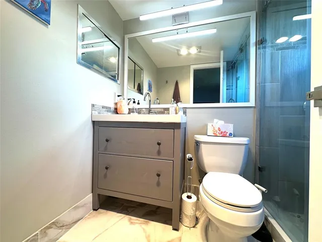 a bathroom with a sink mirror vanity and toilet
