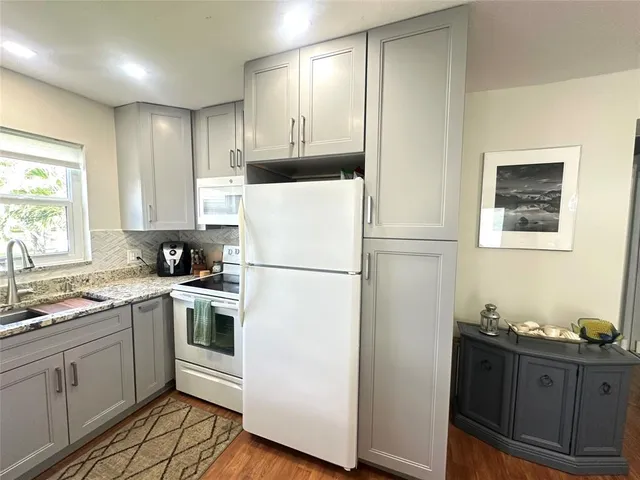a kitchen with a refrigerator sink and cabinets
