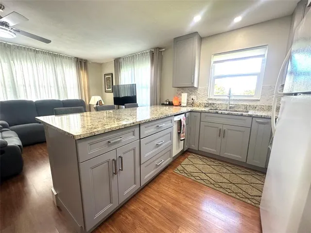 a kitchen with granite countertop cabinets sink and window
