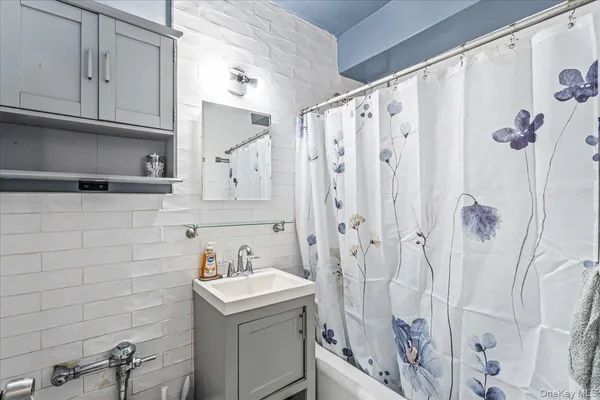a bathroom with a sink a vanity and shower curtain