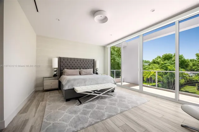 a bed sitting in a spacious bedroom next to a window