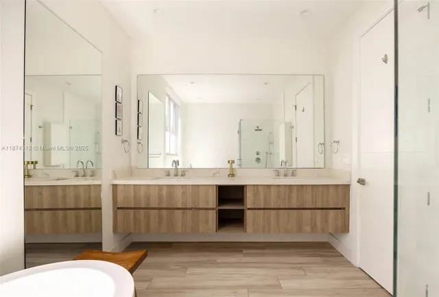 a bathroom with a sink mirror and shower