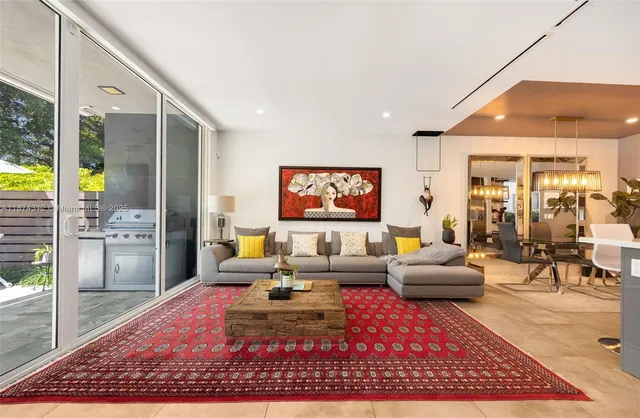 a living room with furniture a rug and a large window