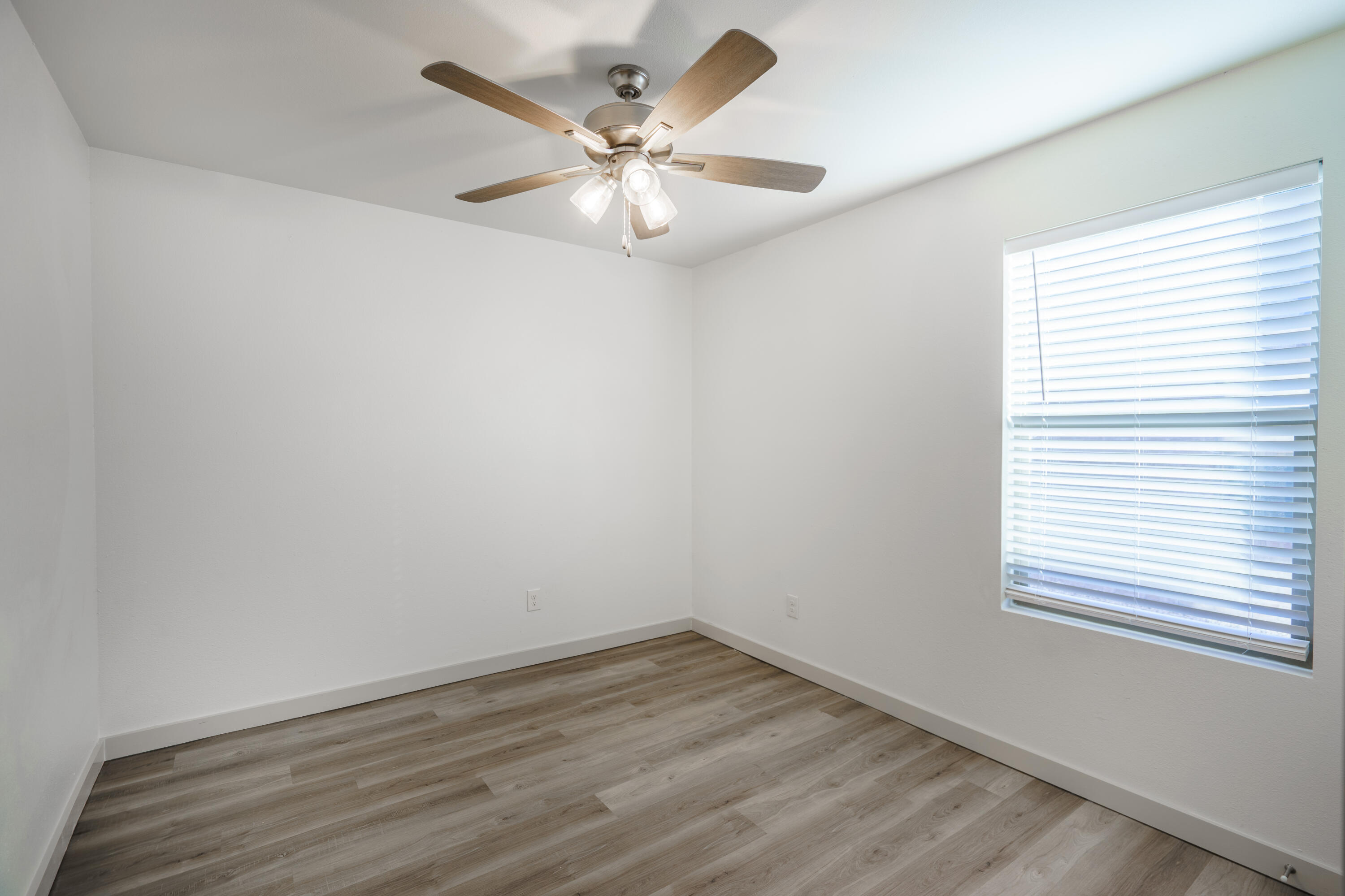 2208 N Avenue North Lubbock, TX 79403 - Photo 9 of 13 an empty room with wooden floor and windows
