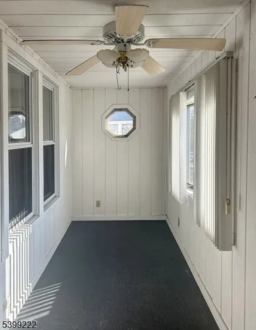 a view of a room with a ceiling fan and window