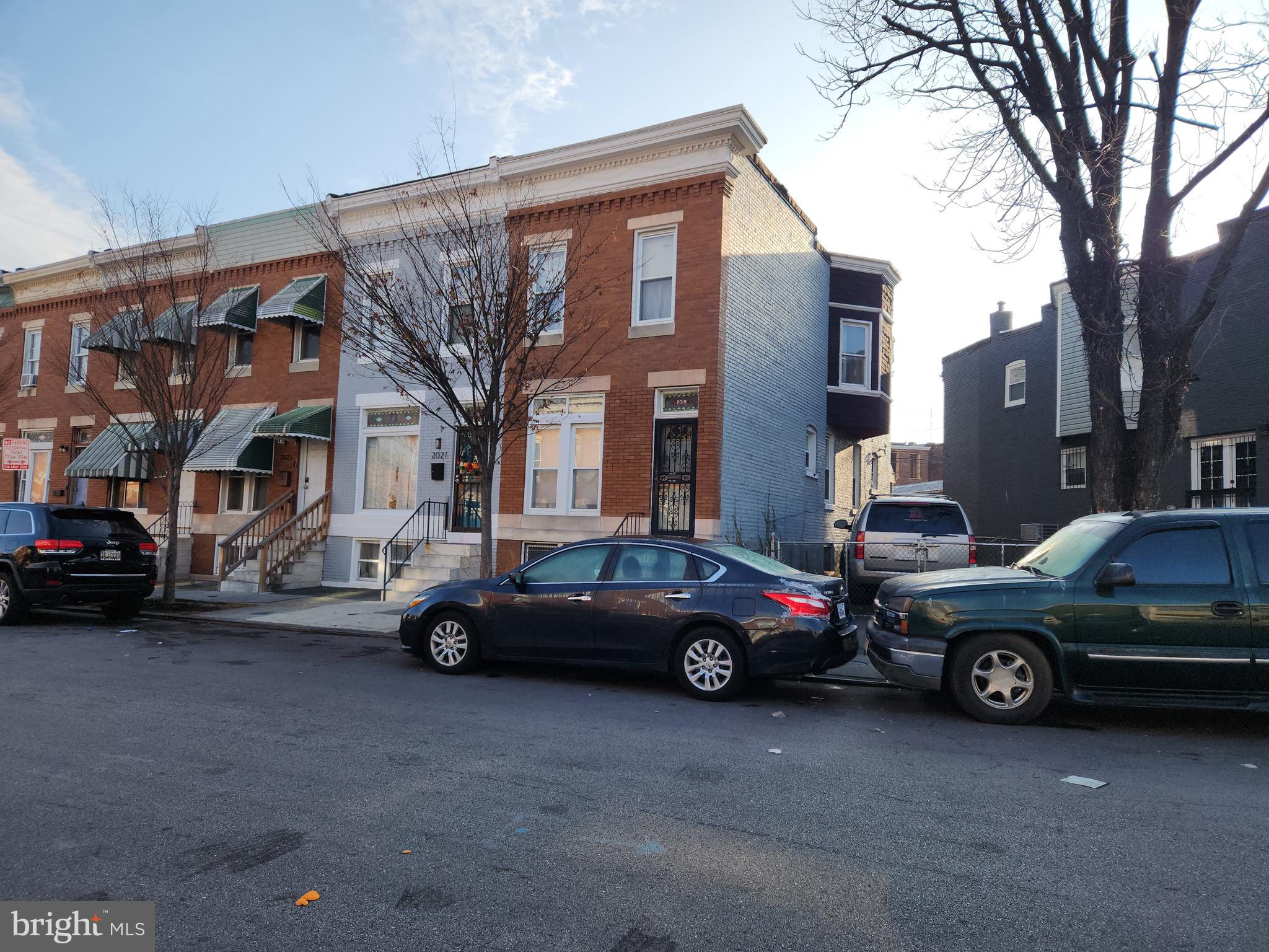2019 Cecil Avenue Baltimore, MD 21218 - Photo 2 of 17 a car parked in front of a brick house