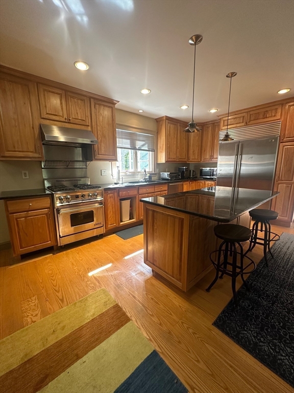 8 Crescent Street Plympton, MA 02367 - Photo 5 of 16 a kitchen with stainless steel appliances granite countertop a stove top oven a sink dishwasher a dining table and chairs with wooden floor
