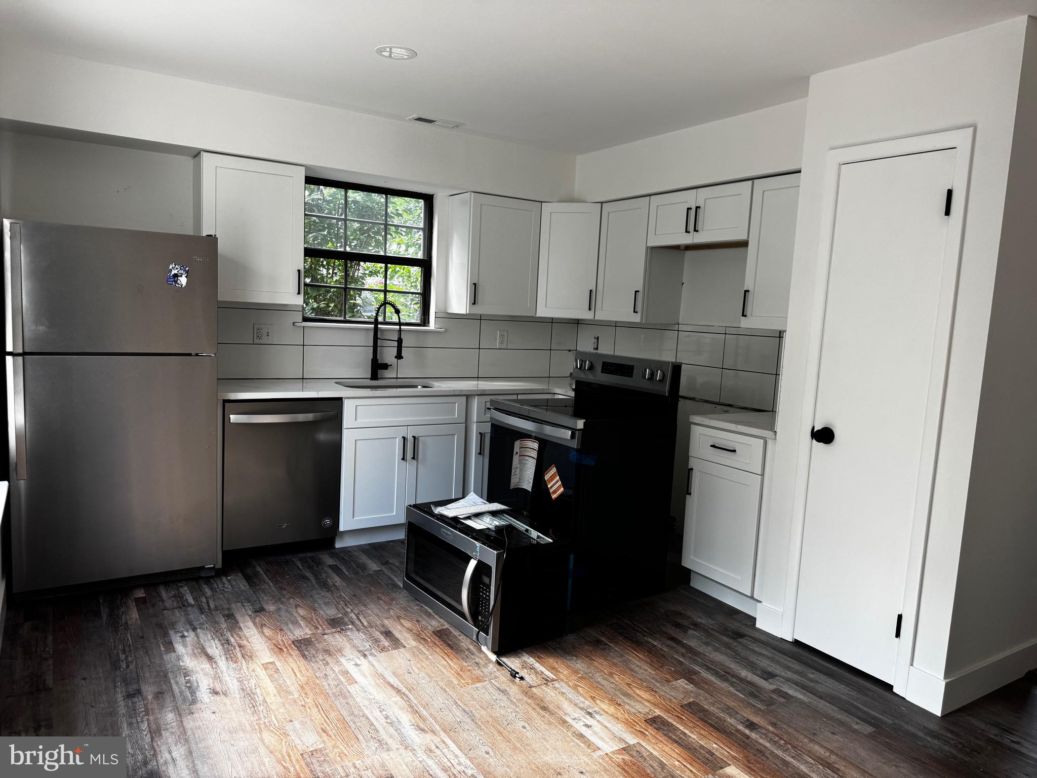 633 Foxton Court Mantua, NJ 08051 - Photo 14 of 14 a kitchen with stainless steel appliances granite countertop a refrigerator a sink dishwasher a stove and white countertops with wooden floor
