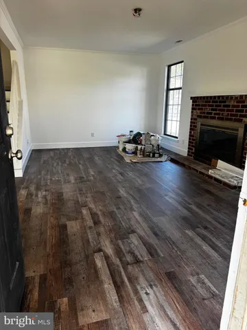 a view of empty room with wooden floor and fireplace