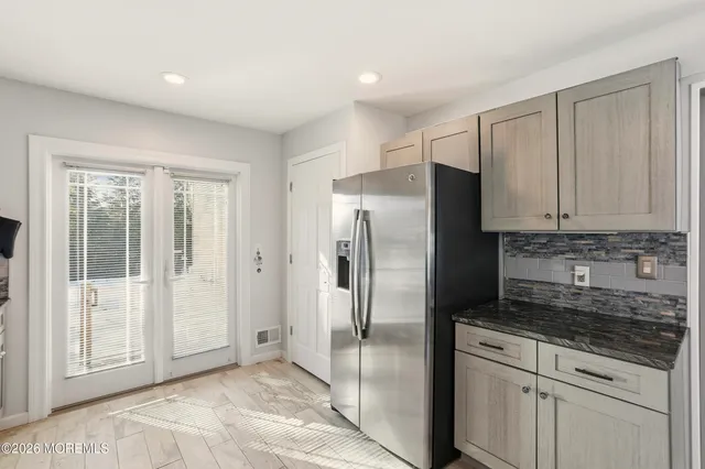a kitchen with stainless steel appliances granite countertop a refrigerator and a sink