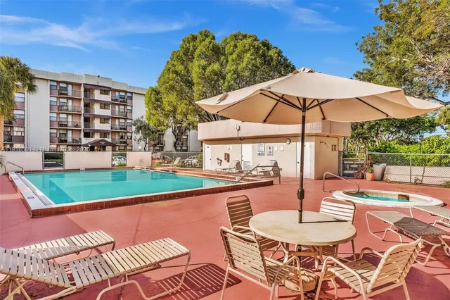 a patio with a table and chairs under an umbrella