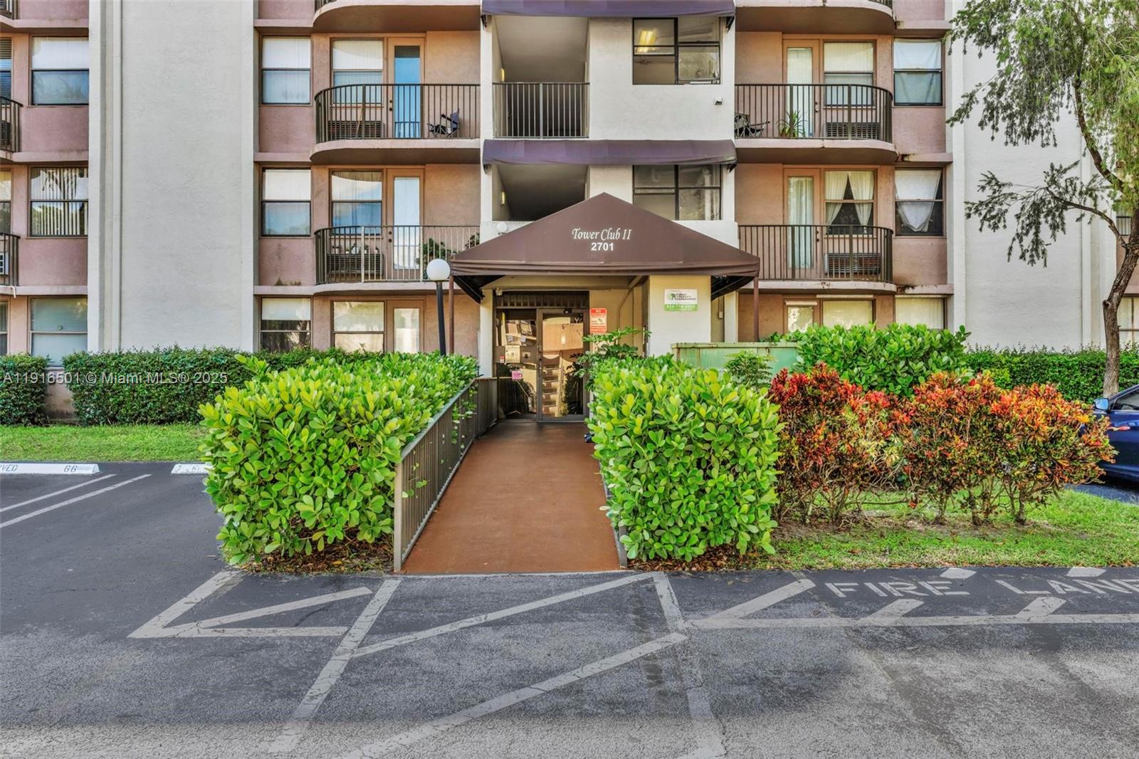 2701 Riverside Drive, Unit 303B Coral Springs, FL 33065 - Photo 18 of 19 front view of a brick house with a yard