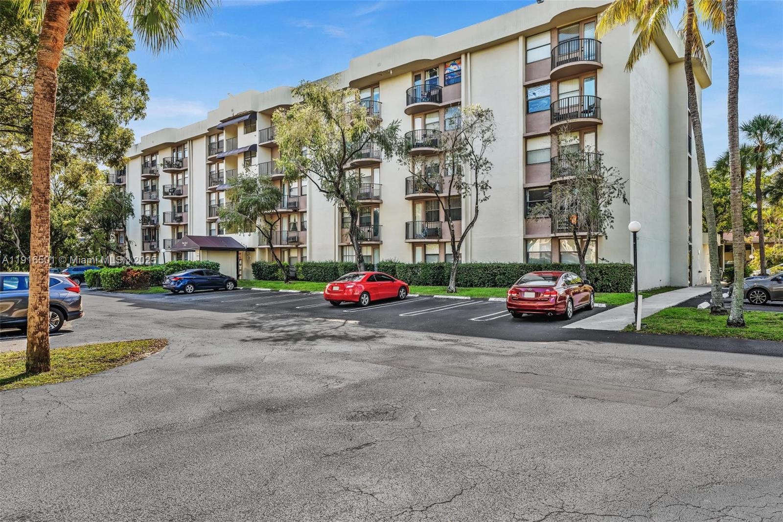 2701 Riverside Drive, Unit 303B Coral Springs, FL 33065 - Photo 19 of 19 a building with cars parked in front of it