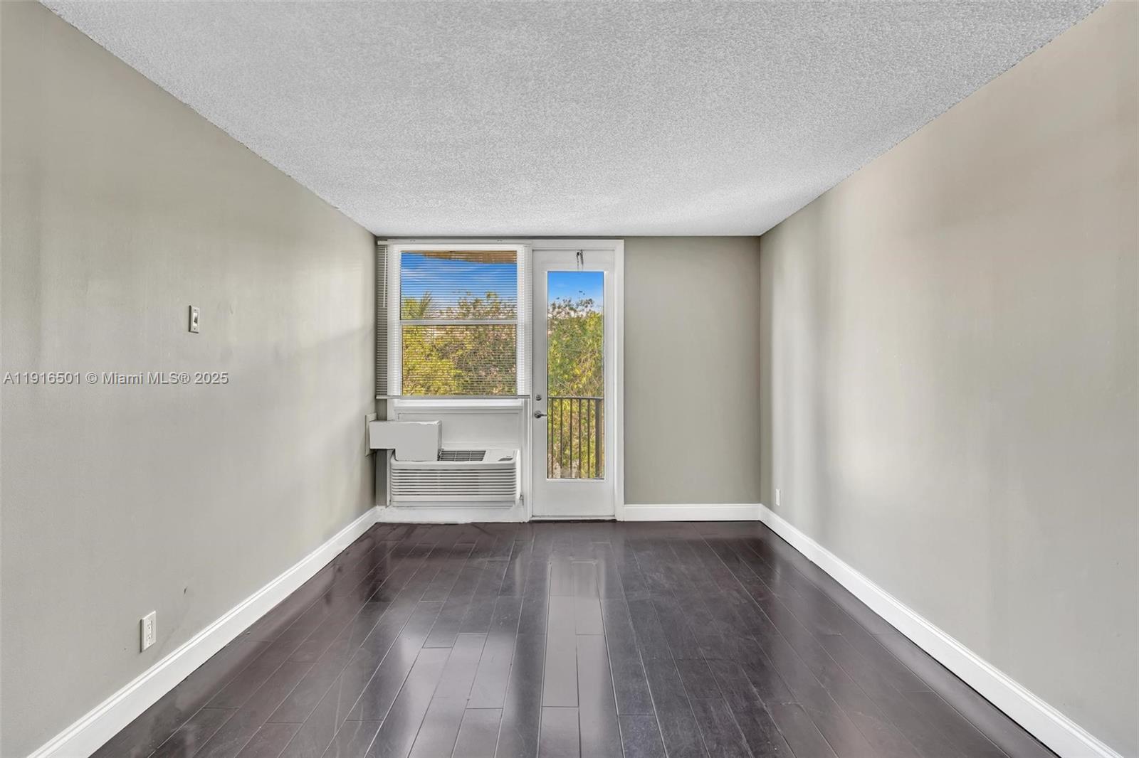 2701 Riverside Drive, Unit 303B Coral Springs, FL 33065 - Photo 3 of 19 an empty room with wooden floor and windows