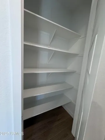 a view of walk in closet with empty racks