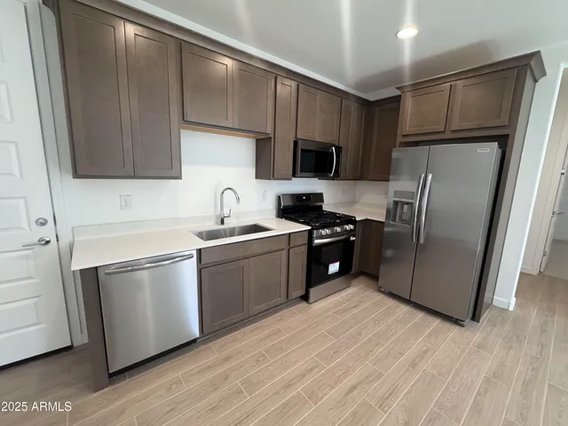 a kitchen with a refrigerator sink and wooden cabinets