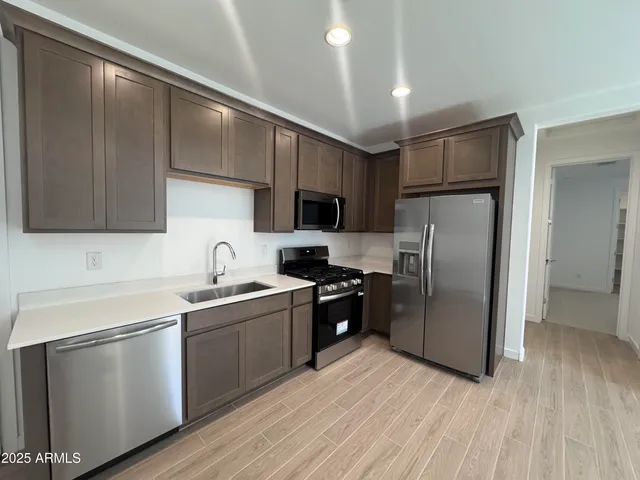 a kitchen with a sink stainless steel appliances and cabinets