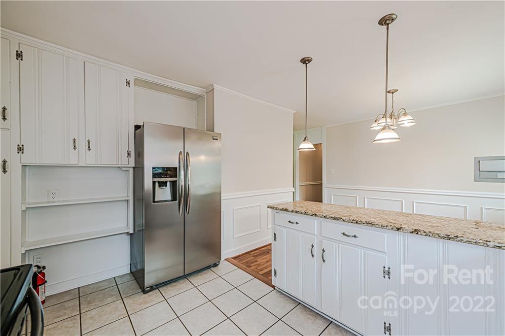 4301 Applegate Road Charlotte, NC 28209 - Photo 9 of 21 a kitchen with white cabinets and refrigerator
