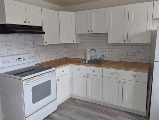 a kitchen with white cabinets and white appliances
