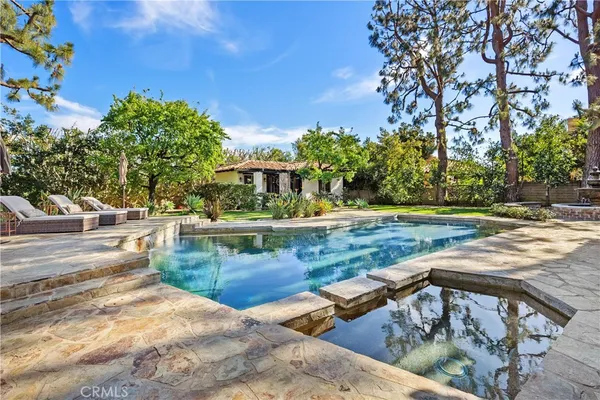 a view of a swimming pool with a patio and a yard