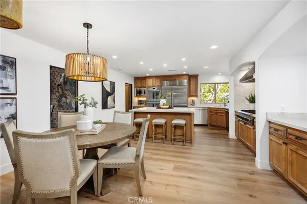 a view of a dining room and livingroom with furniture wooden floor a chandelier