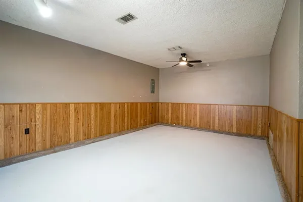 an empty room with a ceiling fan and stairs