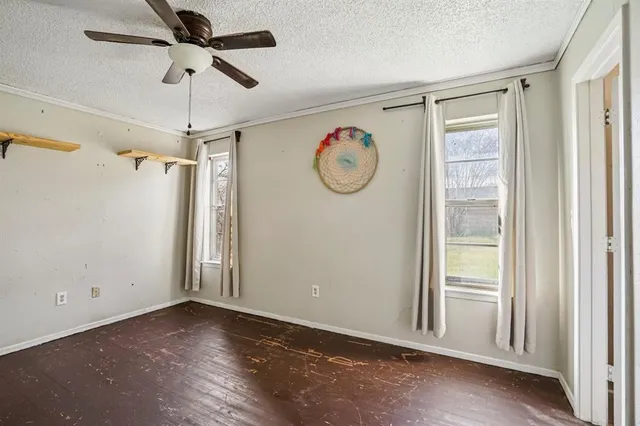 a view of a hallway with wooden floor and a chandelier fan