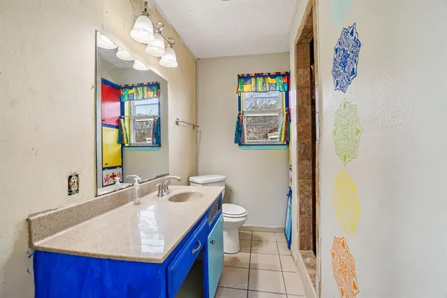 a bathroom with a sink mirror vanity and toilet