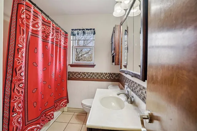 a bathroom with a sink a toilet and shower curtain