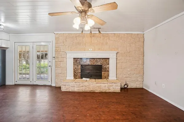 an empty room with windows and fireplace