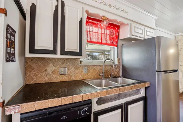 a kitchen with stainless steel appliances a sink cabinets and a window