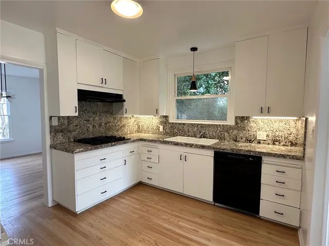 a kitchen with granite countertop a sink and cabinets